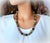 The length of the necklace is 24 inches (61 cm). The size of the smooth round beads is 12 mm. The necklace is fastened...