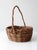 A vintage handwoven wicker basket with a rounded form and an easy arched handle, crafted in natural fibers with subtle...