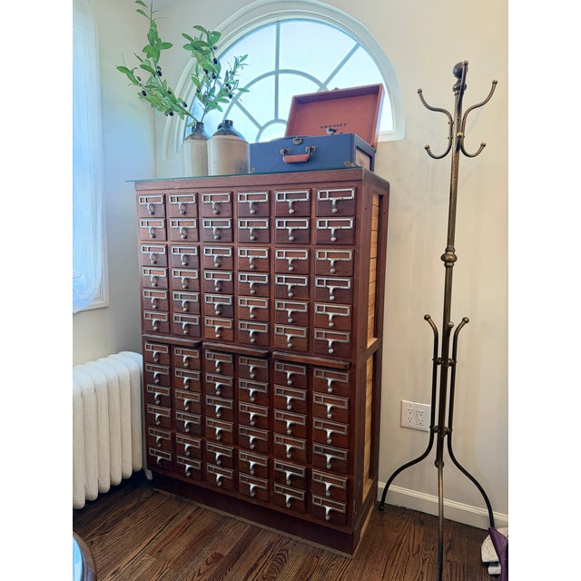 Vintage library card catalog cabinet in excellent condition. Beautiful warm wood tone with original hardware and an...