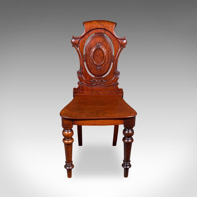 This is an antique shield back hall chair. A Scottish, walnut side or reception seat, dating to the High Victorian period,...