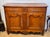 An 18th century French walnut buffet with a shaped top over two long drawers, each fitted with pierced metal escutcheon...