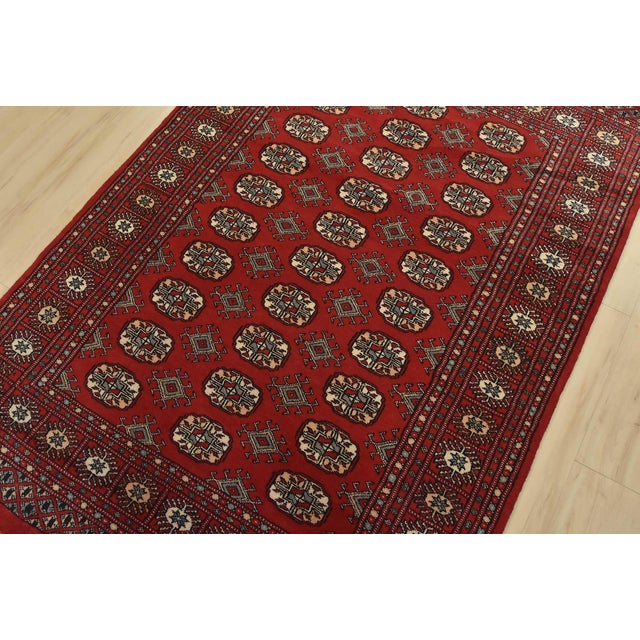 A tribal Bokhara rug hand-knotted with fine wool on a cotton foundation. This rug features rows of repeating medallions...