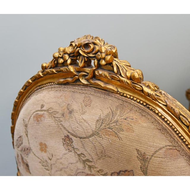 Elegant pair of French Louis XVI style giltwood bergere armchairs Each chair features a rounded upholstered back...