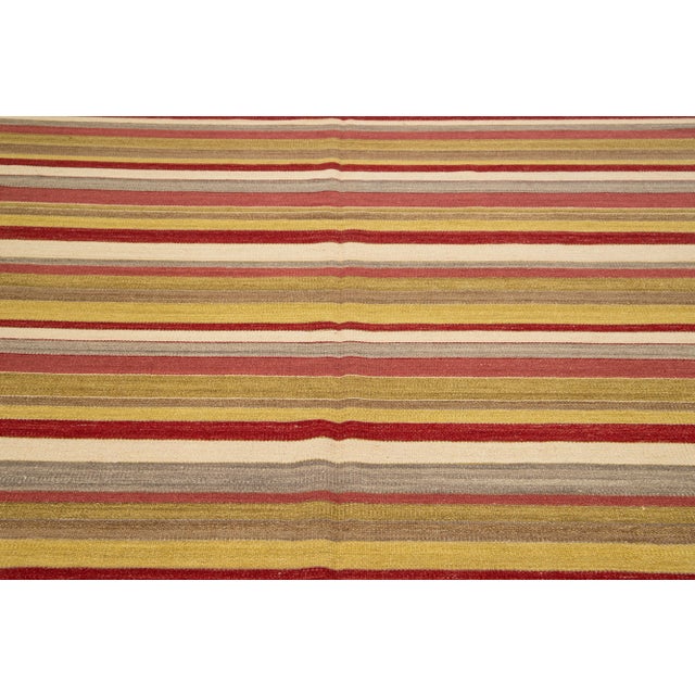 Beautiful Modern Kilim hand-knotted wool rug with multicolor accents in an all-over geometric stripe design. This rug...