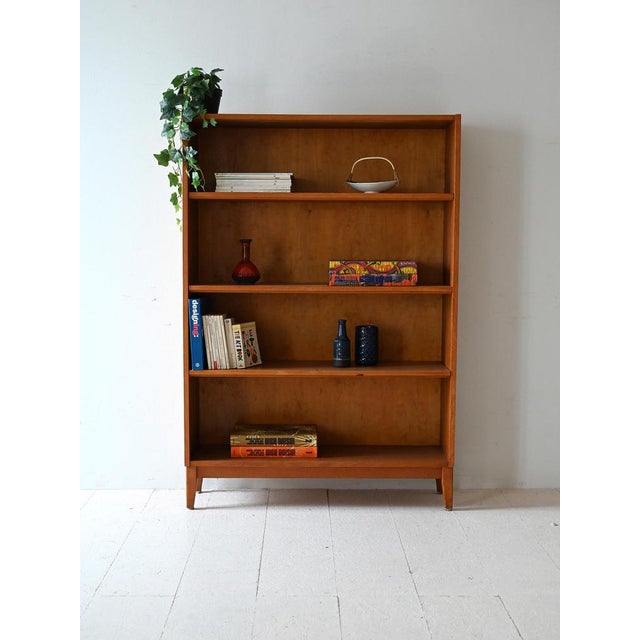 1950s/60s bookcase in light oak, with four shelves and shaped feet, with a sober and functional style. Bookcase with a...