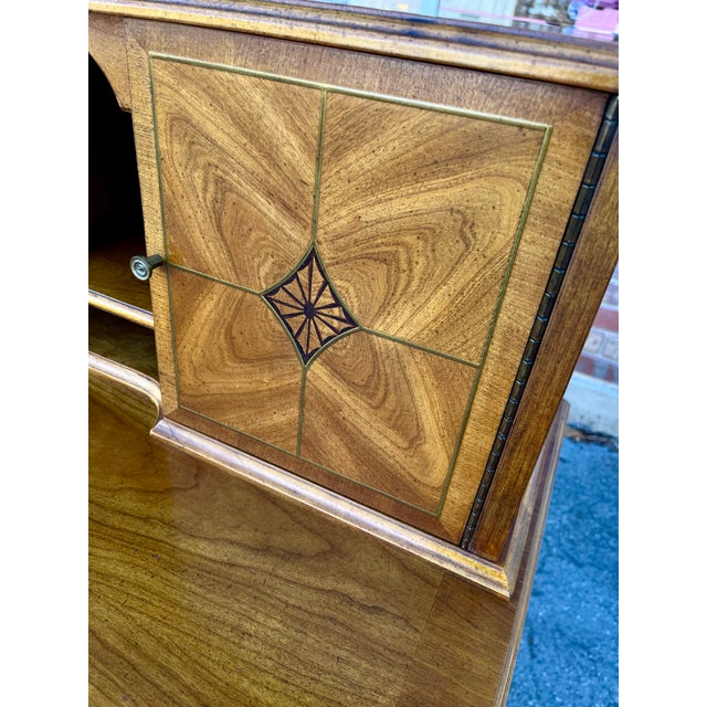 Vintage writing desk by Bernhardt. Features several open pigeon holes, bookmatched panel doors with brass inlay, wide edge...