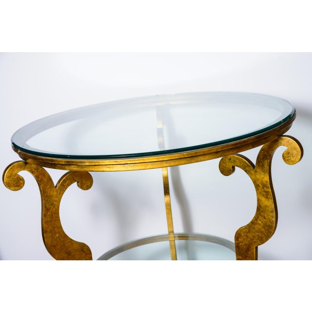 Just in! This French Art Deco Style Gilt Iron Round Two Tier, Beveled Glass Top Center Table with three scrolled legs....