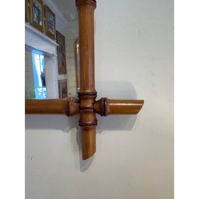 This is a French antique faux-bamboo wall mirror with a hand-carved wood frame. The frame is wood that has been shaped and...