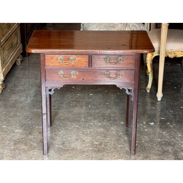 18th century English mahogany side table with a molded top and rounded front corners. Two short drawers sit over one long...