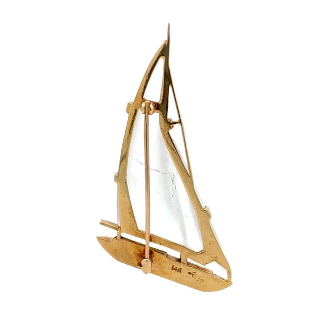 Distinctive 14K yellow gold sailboat brooch featuring carved frosted quartz sails and a sleek gold hull accented with...