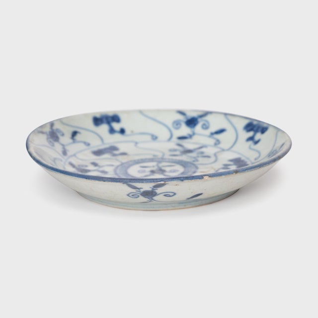 This 19th-century porcelain plate is hand-painted with cobalt underglaze in the blue-and-white manner, loosely brushed...