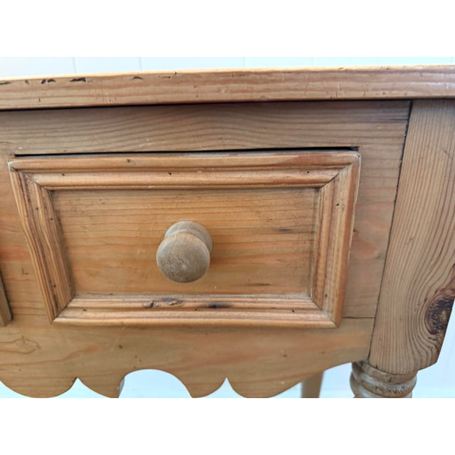 Charming vintage rustic European style pine console table featuring three drawers, beautifully turned legs, and a...