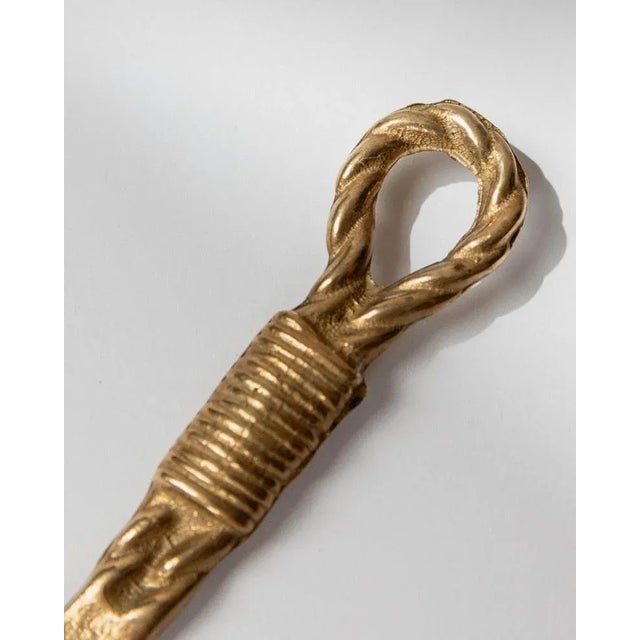 This elegant vintage bottle opener from 1960s Italy is crafted in brass and designed in the shape of a rope with loop. Its...