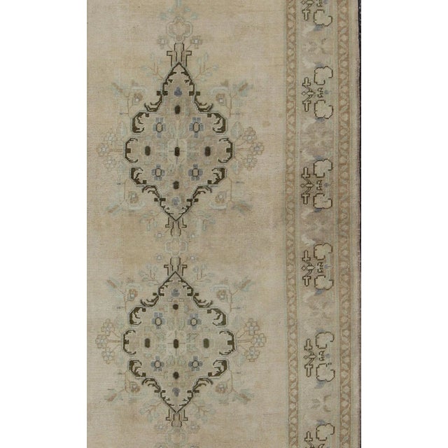 This vintage Oushak beautifully illustrates the impressive craftsmanship and design of Turkish weavers. The large...