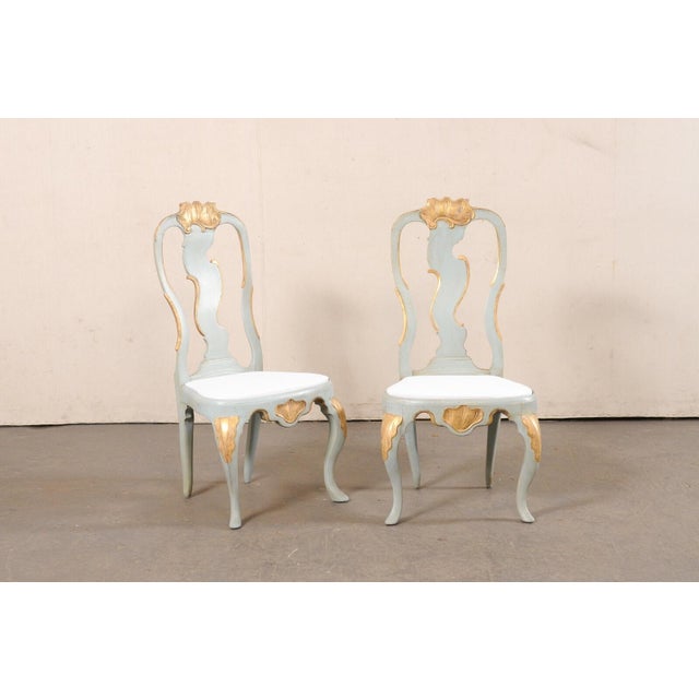 A Danish pair of period Rococo painted and carved-wood side chairs, with upholstery lining on the seats, from the 18th...