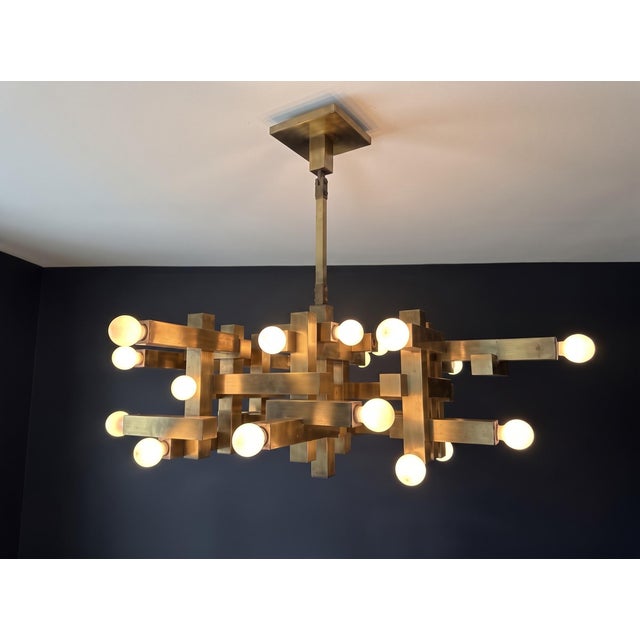 A mid century modern Italian 18 light chandelier made of brushed brass by Gaetano Sciolari. Made in Italy. Circa 1970’s....