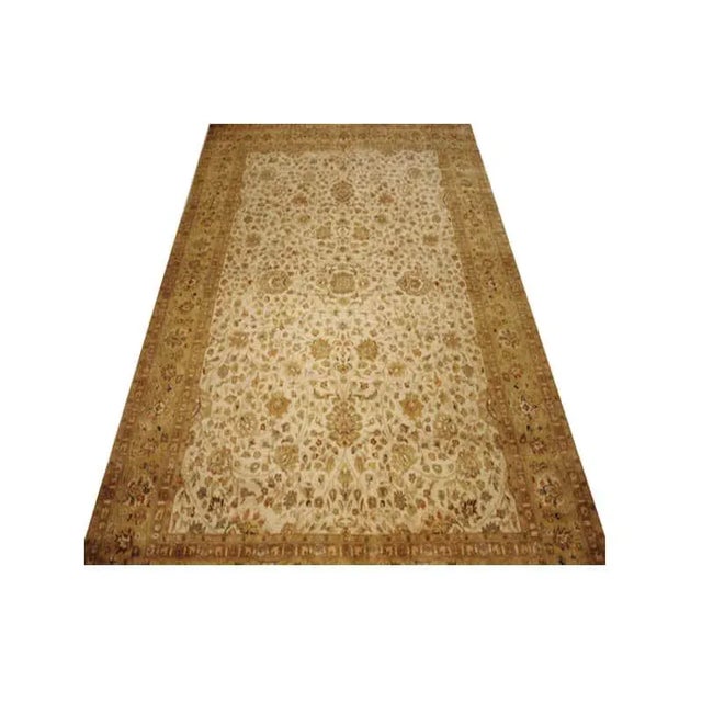 This traditional handwoven Persian Tabriz rug features a beautifully rendered allover floral design. The luxurious ivory-...