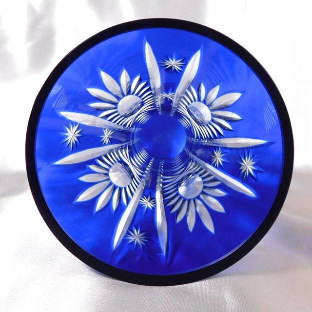 This is a slender Cut to Clear Blue Glass Vase with a wide opening and narrow middle. The vase measures 8.00 inches tall...