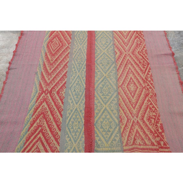Handwoven in wool circa 1950–1960, this 4x6 vintage Kilim, woven in the tradition of a Frazada textile, is a vibrant...
