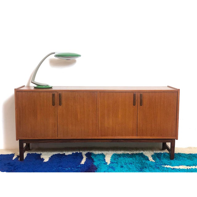 1960s Italian-made sideboard made entirely of teak veneer, restored and sanitized, featuring 4 opening doors with internal...