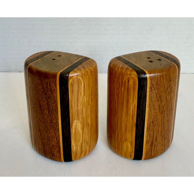 Here is a vintage set of wood salt and pepper shakers, likely dating to the 1970s–80s. Made from laminated hardwoods with...