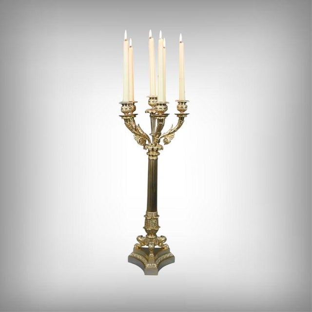This gilt bronze candelabra, typical of the refined elegance of the Restoration period, captivates with its harmonious...