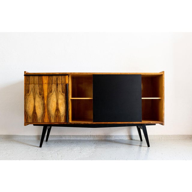 This sideboard was manufactured in Poland in the 1970s The case, drawer and door are finished in walnut veneer with a...