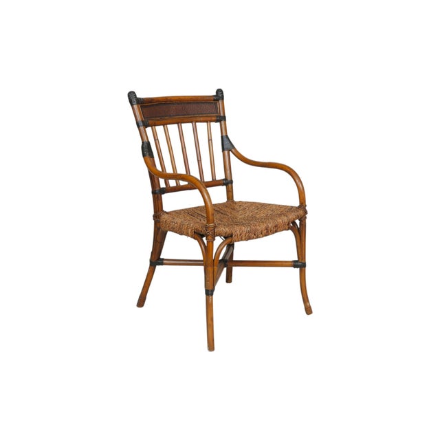 A set of ten bamboo dining chairs with rush seats. Square spindle backs are finished with panels of woven rattan at the...