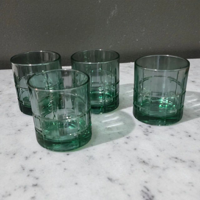 The product is a set of four vintage Anchor Hocking low ball green glasses, made in the United States These mid-century...