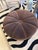 Luxurious brown velvet round ottoman pouf with gorgeous channelled upholstery emanating from central button on top. CD...