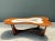 This vintage biomorphic coffee table pairs a sculptural wood base with an eye-catching ceramic mosaic top, embodying mid-...