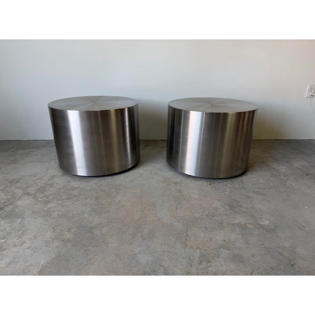 Sleek and timeless pair of vintage Milo Baughman-style drum side tables featuring cylindrical forms in brushed stainless...