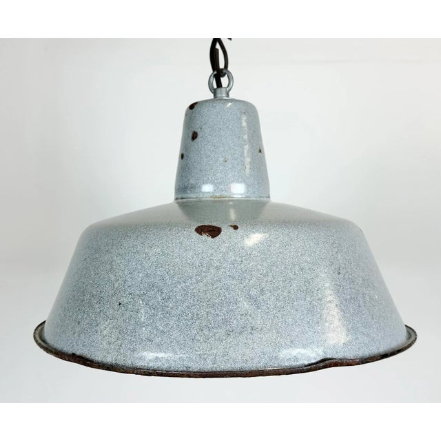 Industrial grey enamel pendant light made in Poland during the 1960s. White enamel inside the shade. Iron top. The...