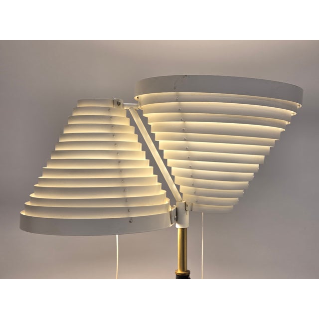 Early Artek A810 floor lamp, manufactured by Valaistustyö, designed by Alvar Aalto in 1959. The lamp has a brass base,...