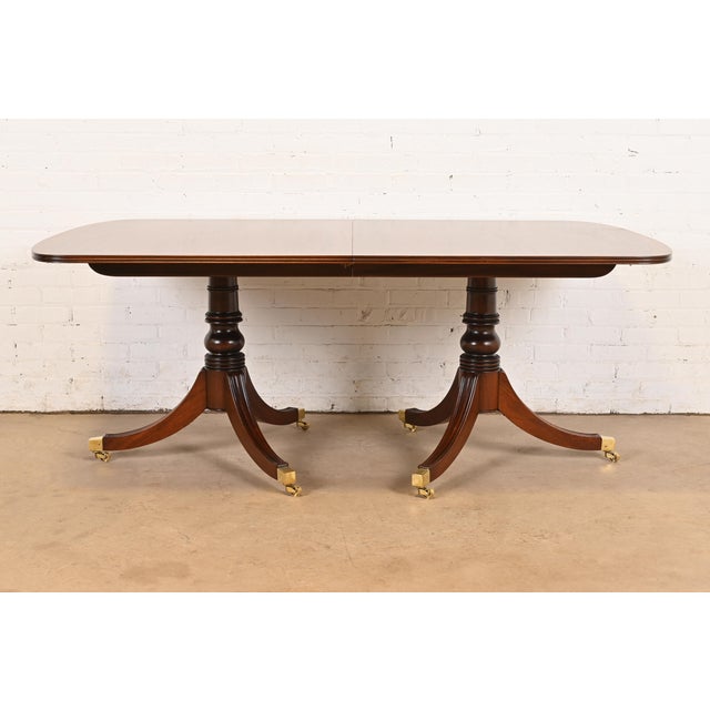 An exceptional Georgian or Regency style double pedestal dining table By Henredon USA, Circa 1980s Gorgeous book-matched...