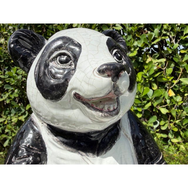 A charming vintage seated panda sculpture crafted in hollow earthenware ceramic with a richly crackled black and white...