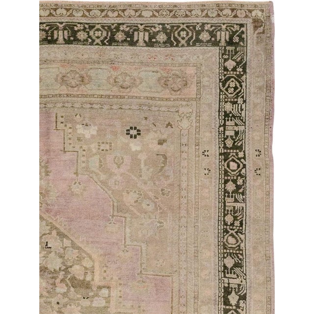 This Mid-20th century Turkish Anatolian small room-size carpet presents a layered composition centered by a large floral...