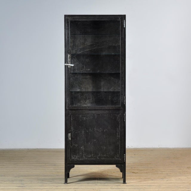 Medical cabinet from the 1930s, manufactured in Hungary. This cabinet is made of iron and glass, creating a rugged...