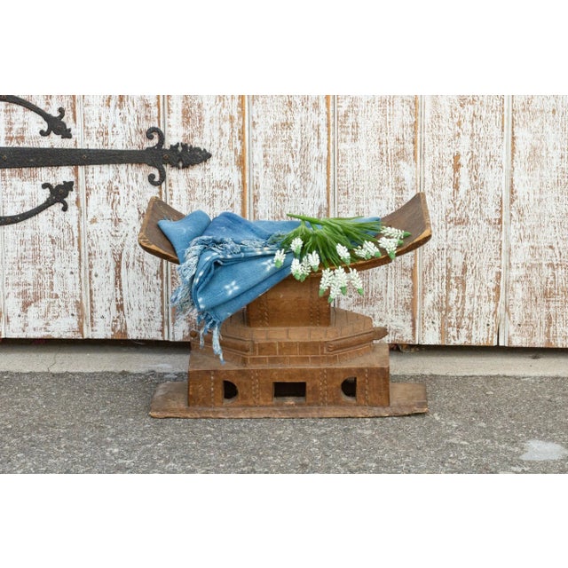 An authentic Ashanti stool, carved from a single piece of wood. With a concave top, a central column rises from a...