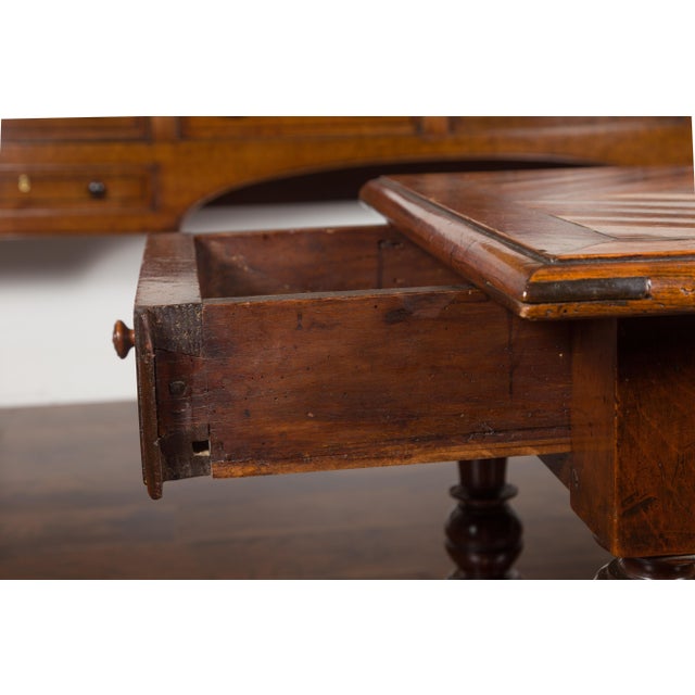 An English walnut parquet top table from the mid-19th century, with single drawer and turned legs. Created in England...