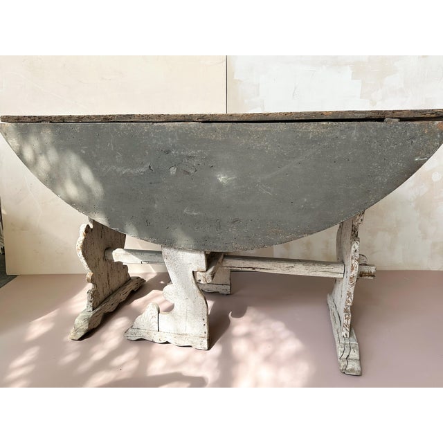 18th century French drop-leaf table, crafted in solid wood and featuring two hinged side leaves that can be raised or...