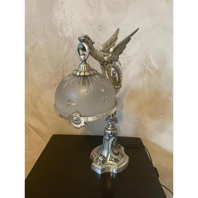 Exceptional Art Nouveau table lamp in silver bronze, representing a chimera holding in his mouth the chopped glass of the...