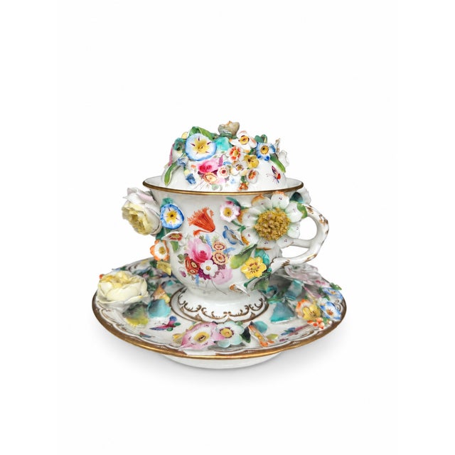 An elaborate three-piece porcelain ensemble with individually modelled flowers and foliage, painted bouquets, butterflies...