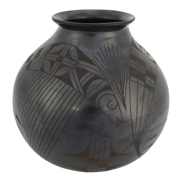 This black-on-black pottery olla represents a significant piece of 20th-century Mexican ceramic art. Handcrafted in the...
