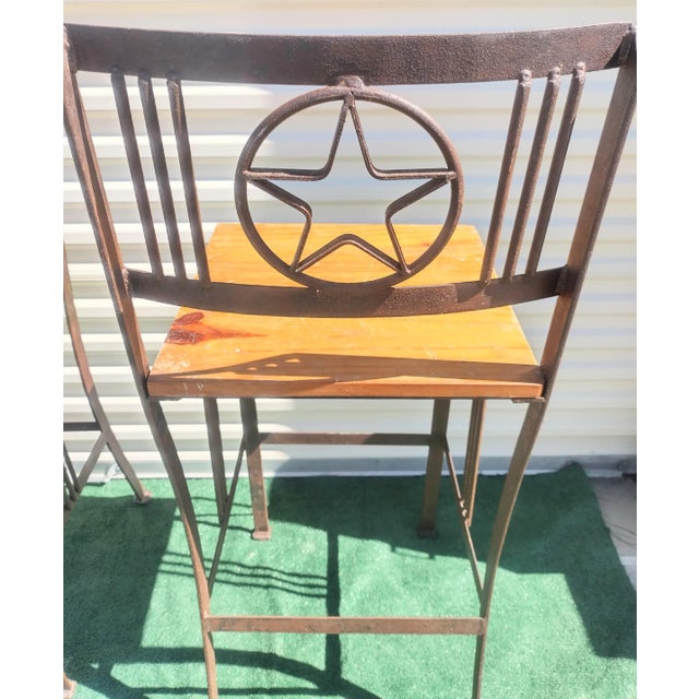 A set of 4 fabulous iron and wood bar stools. The bar stools feature a fabulous Texas star logo back with wood seat. The...