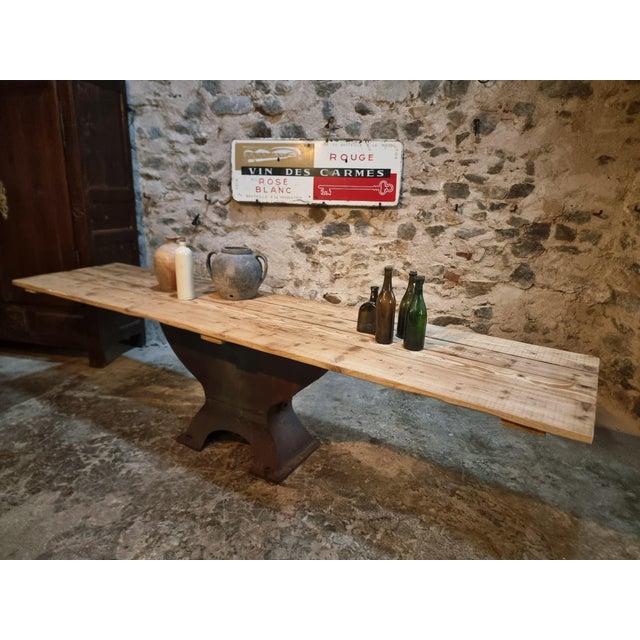 Antique French industrial table combining a cast iron base with a solid pine plank top. The cast iron base originates from...