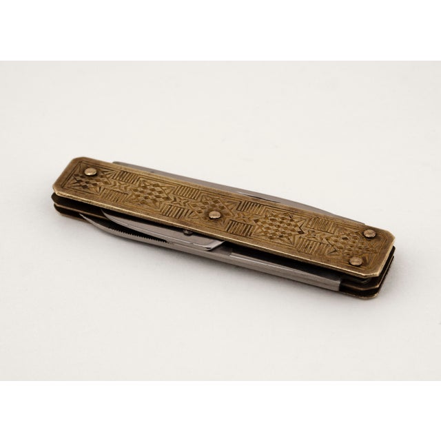 This elegant men's pocket multitool from around 1950 stands out for its decorative and intricate design. The solid brass...