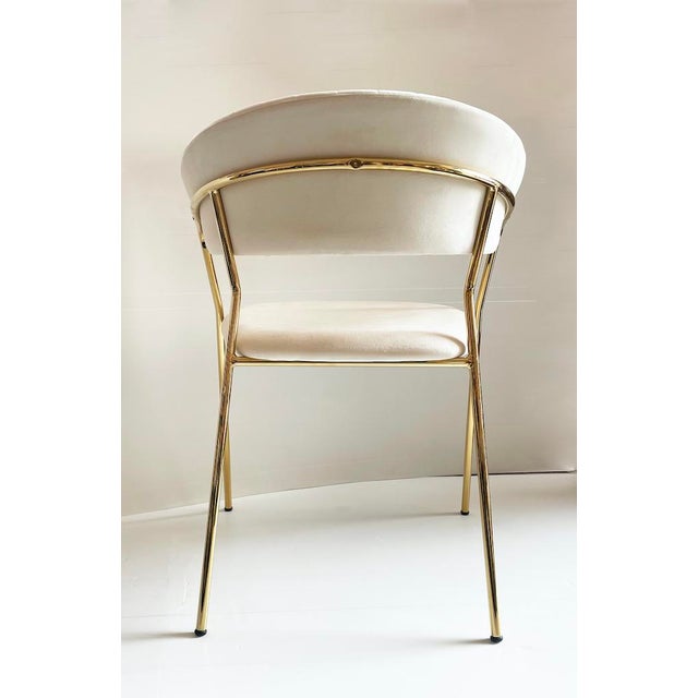 Particular contemporary chair with polished brass structure and cream-colored velvet covering. Period: Contemporary...