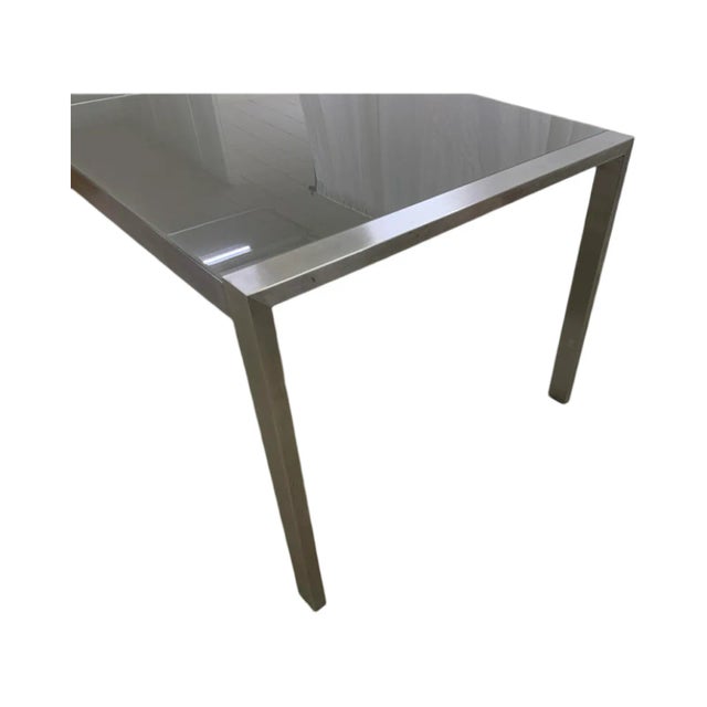 This is a Brueton high table, the Custom Stainless Steel Table w/ Gray Frosted Glass. The table has two frosted panes of...