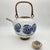 great round tea pot with circle motif. thin spout with cane handle